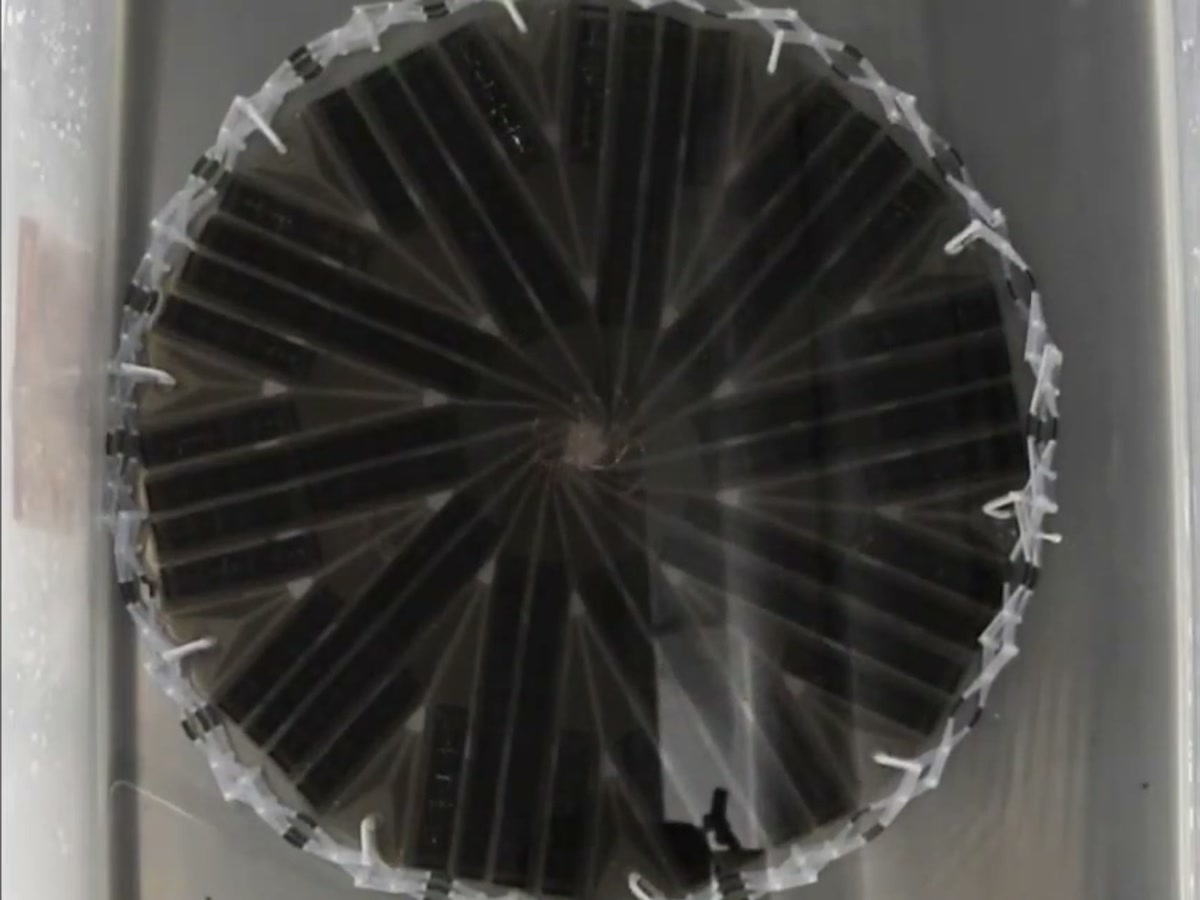 The 3D-printed origami solar array fully expanded in a water bath, flexible solar panels arranged in a spiral over the flasher origami substrate
